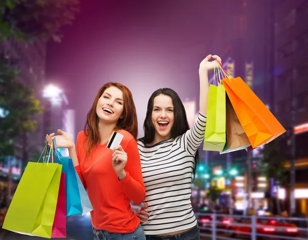 Twee glimlachend tienermeisjes met shopping tassen — Stockfoto