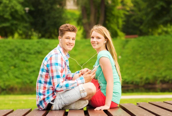 Lachende paar met smartphone en koptelefoon — Stockfoto