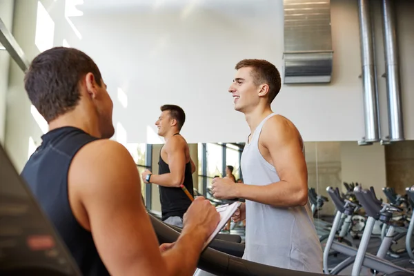 Männer trainieren auf Laufband im Fitnessstudio — Stockfoto