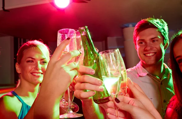 Lachende vrienden met wijn glazen en bier in club — Stockfoto