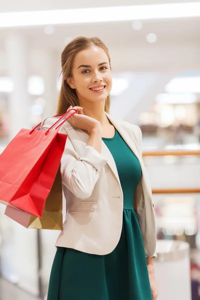 Jovem feliz com sacos de compras no shopping — Fotografia de Stock