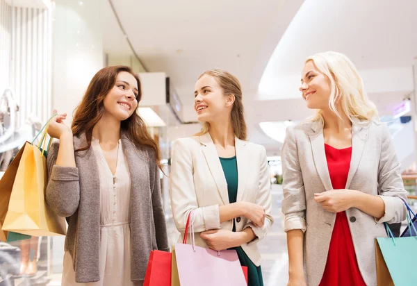 Mujeres jóvenes felices con bolsas de compras en el centro comercial —  Fotos de Stock