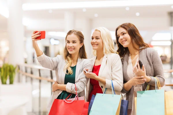 Mujeres con smartphones comprando y tomando selfie —  Fotos de Stock