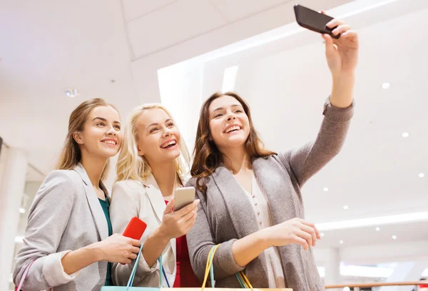 Mujeres con smartphones comprando y tomando selfie — Foto de Stock