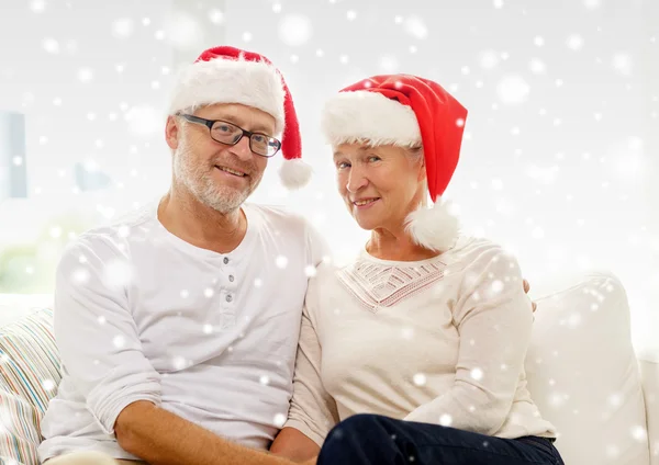 Happy senior couple in santa helper hats at home — Stock Photo, Image