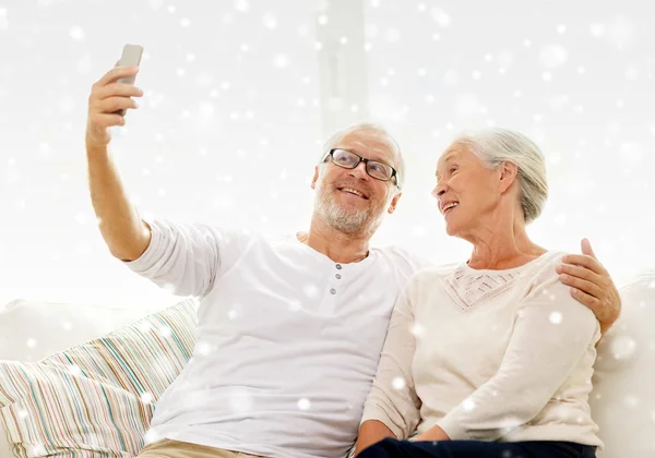 Happy senior couple with smartphone at home — Stock Photo, Image