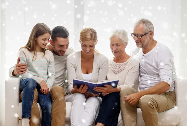 Famiglia felice con libro o album fotografico a casa — Foto Stock