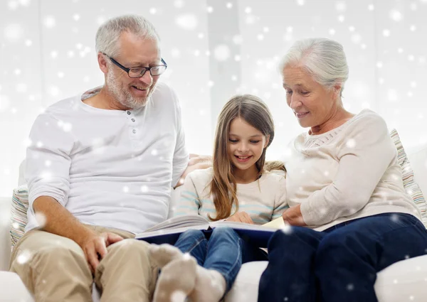 Famiglia sorridente con libro a casa — Foto Stock