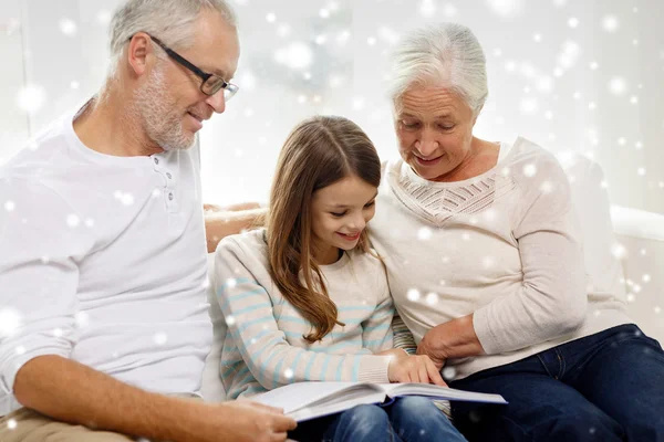 Famille souriante avec livre à la maison — Photo