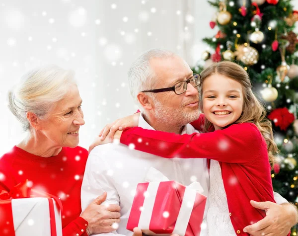 Famiglia sorridente con regali a casa — Foto Stock