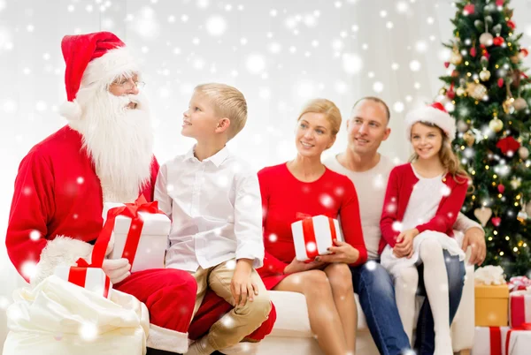 Famiglia sorridente con Babbo Natale e regali a casa — Foto Stock