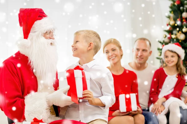 Lachende familie met santa claus en geschenken thuis — Stockfoto