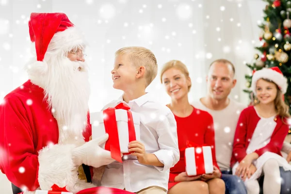 Sonriente familia con santa claus y regalos en casa — Foto de Stock