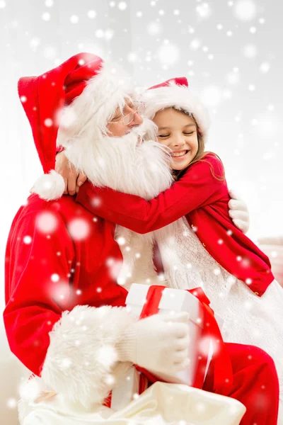 圣诞老人与礼物在家里的小女孩微笑着 — 图库照片