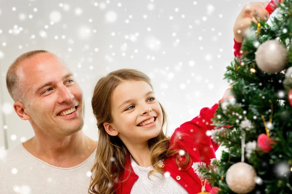 Lächelnde Familie schmückt Weihnachtsbaum zu Hause — Stockfoto