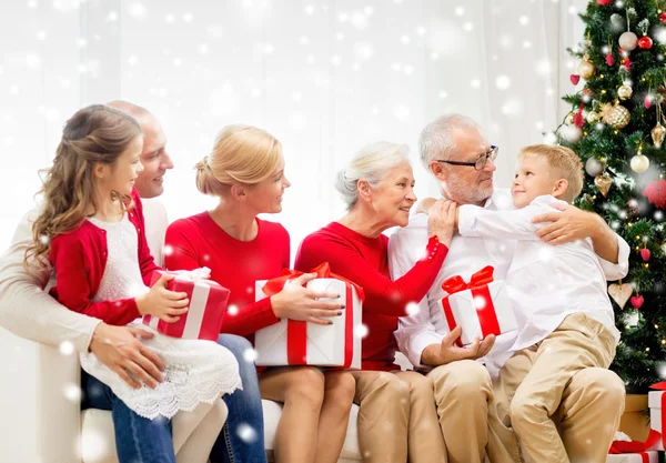 Família sorridente com presentes em casa Imagens De Bancos De Imagens