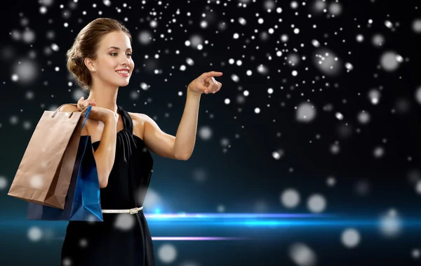 Mujer sonriente en vestido con bolsas de compras — Foto de Stock