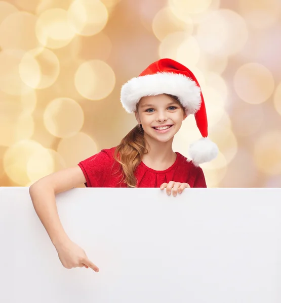 Meisje in helper kerstmuts met een leeg wit bord — Stockfoto