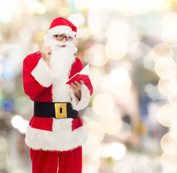 Muž v kostýmu santa Clause s Poznámkový blok — Stock fotografie