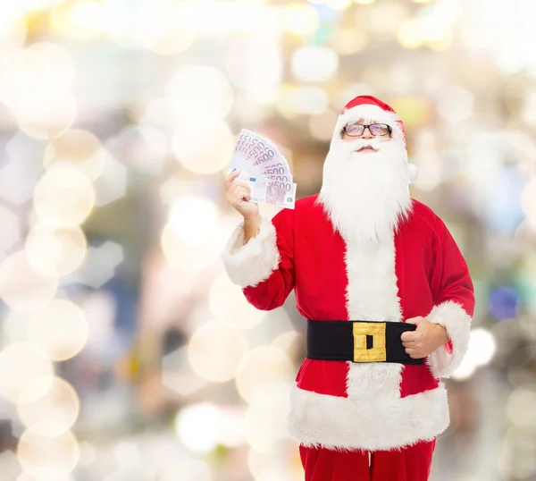 Hombre disfrazado de santa claus con dinero en euros — Foto de Stock