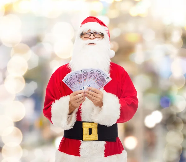 Hombre disfrazado de santa claus con dinero en euros — Foto de Stock