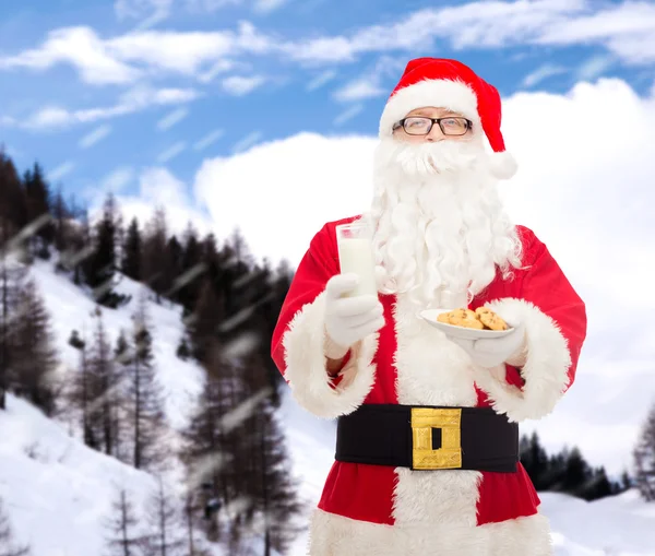 Père Noël avec verre de lait et biscuits — Photo