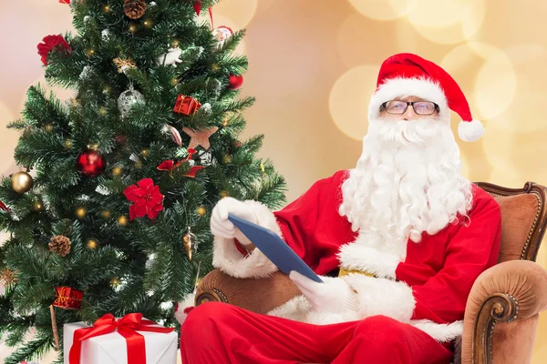 Man in costume of santa claus with tablet pc — Stock Photo, Image