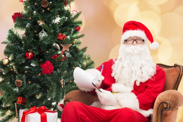 Uomo in costume di Babbo Natale con blocco note — Foto Stock