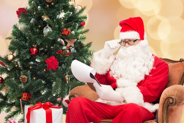 Homme en costume de Père Noël claus avec bloc-notes — Photo