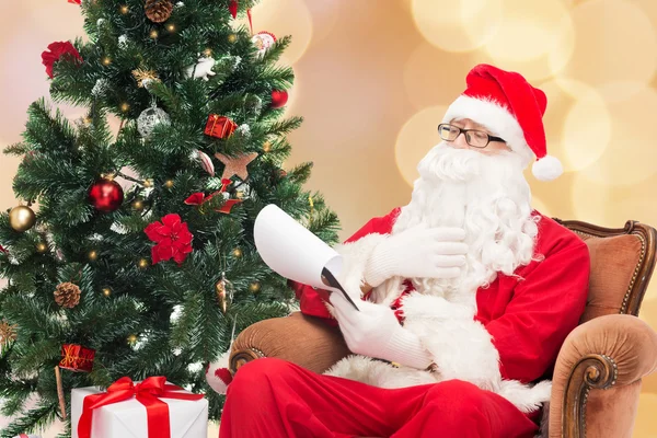 Man in costume of santa claus with notepad — Stock Photo, Image