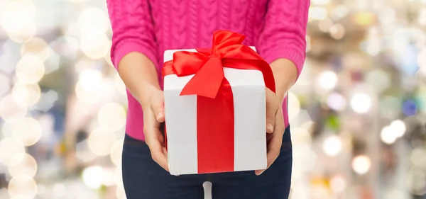 Primo piano della donna in maglione rosa contenente confezione regalo — Foto Stock