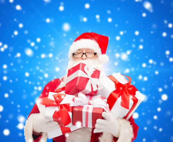 Man in kostuum van de kerstman met geschenkdozen — Stockfoto