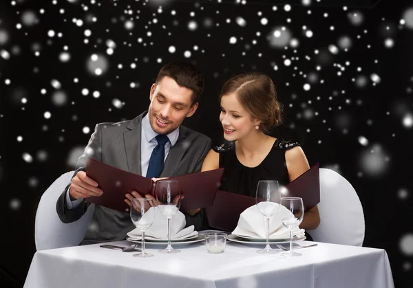 Casal sorrindo com menus no restaurante — Fotografia de Stock