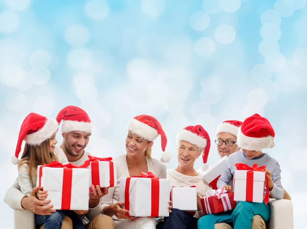 Happy family in santa helper hats with gift boxes — Stock Photo, Image