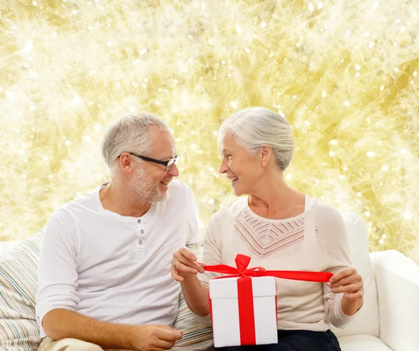 Feliz pareja de ancianos con caja de regalo en casa —  Fotos de Stock