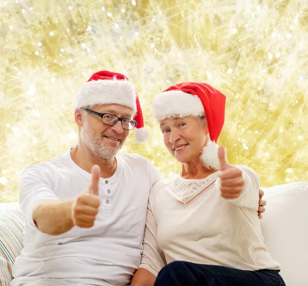 Feliz casal sênior em santa helper chapéus — Fotografia de Stock