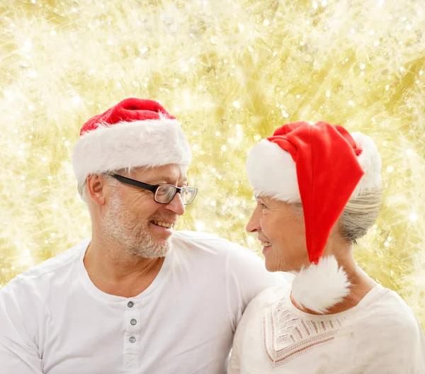 Šťastný starší pár v santa pomocníka klobouky — Stock fotografie