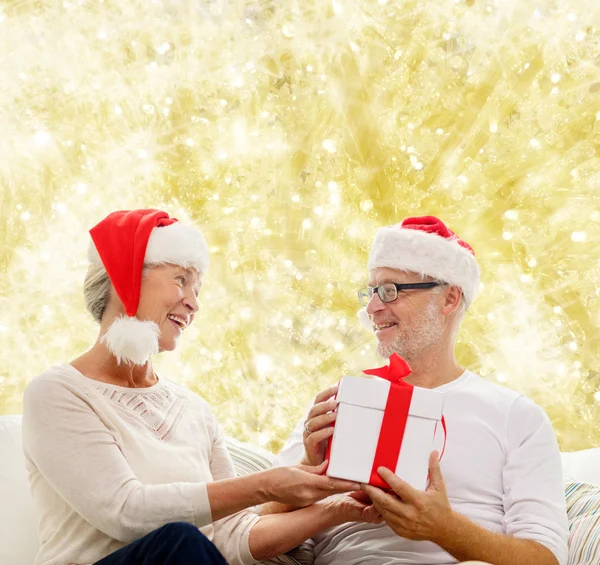 Feliz pareja de ancianos con caja de regalo en casa —  Fotos de Stock