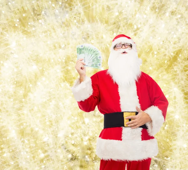 Hombre disfrazado de santa claus con dinero en euros — Foto de Stock