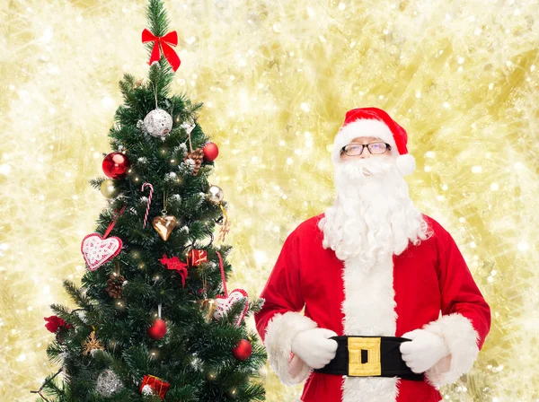 Man in costume of santa claus with christmas tree — Stock Photo, Image