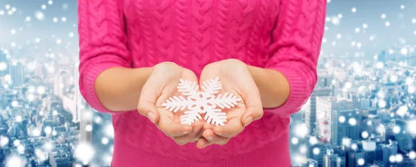 Close up of woman in sweater holding snowflake — Stock Photo, Image