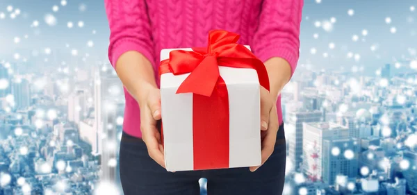 Close up of woman in pink sweater holding gift box — Stock Photo, Image