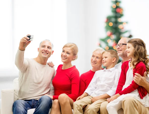 Sonriente familia con cámara en casa — Foto de Stock