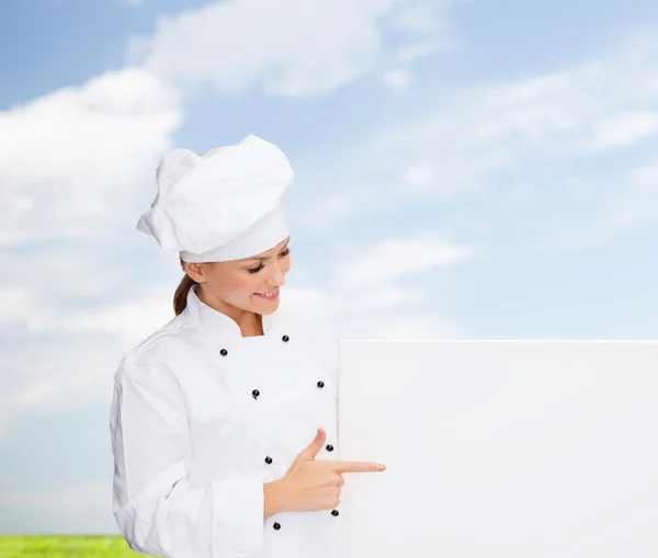 Chef feminino sorridente com placa branca em branco — Fotografia de Stock