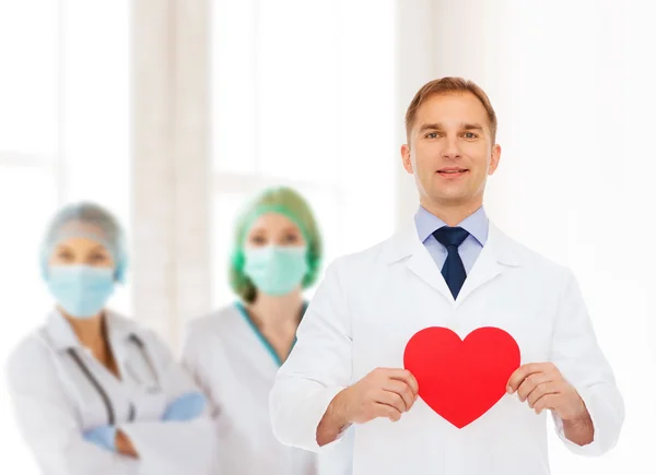 Smiling male doctor with red heart — Stock Photo, Image