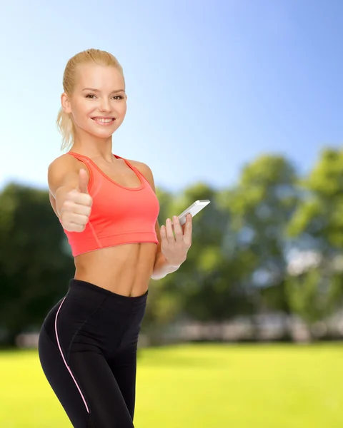 Lachende sportieve vrouw met smartphone — Stockfoto