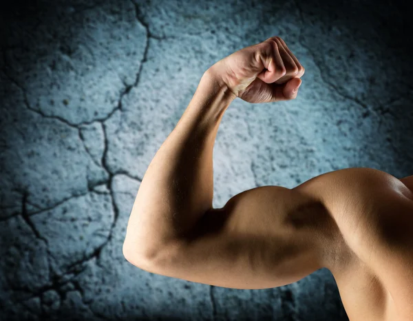 Zamknij się młody człowiek, wyginanie i Wyświetlono biceps — Zdjęcie stockowe