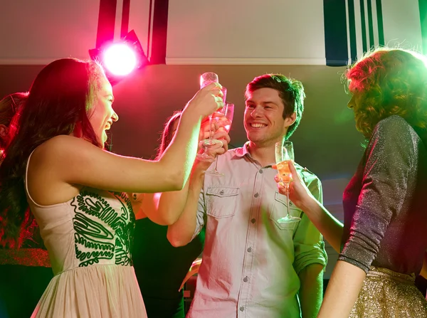 Улыбающиеся друзья с бокалами шампанского в клубе — стоковое фото