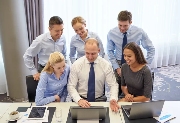 Усміхнені ділові люди з ноутбуком в офісі — стокове фото