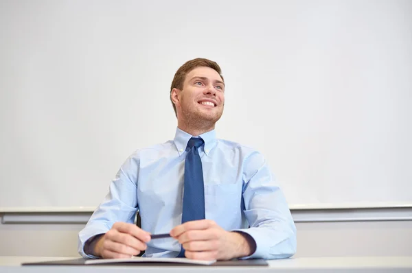 Empresário sorridente sentado no cargo — Fotografia de Stock